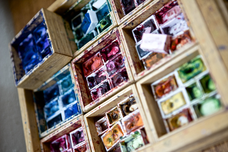 Närbild på en färgstark akvarellpalett i konstnärsateljén.