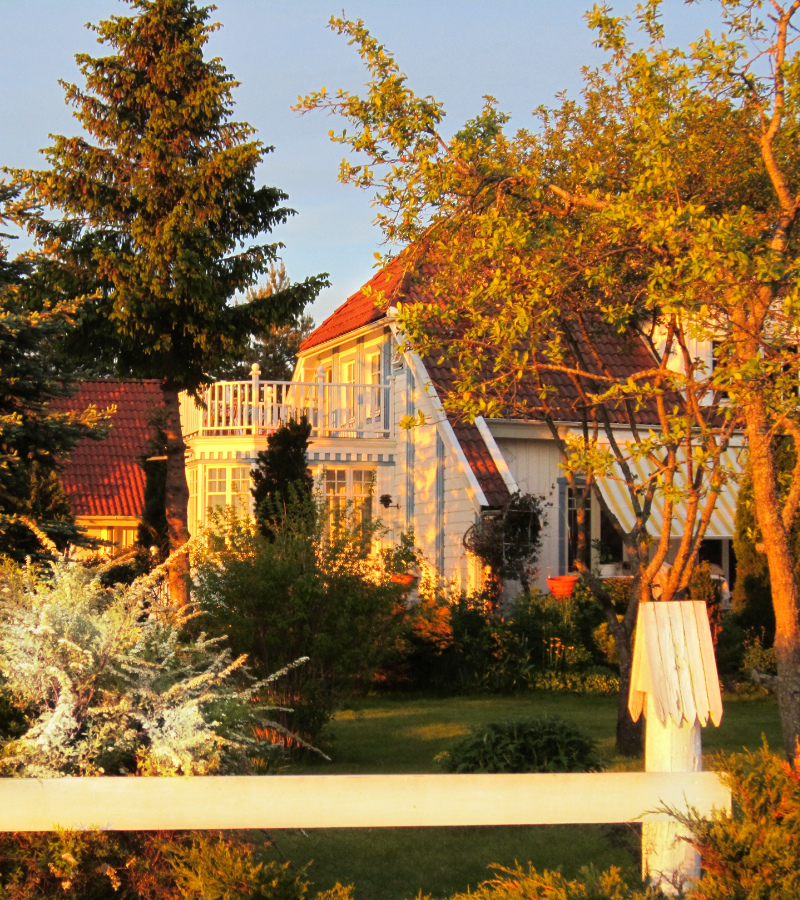 Den vita ateljébyggnaden i Gråbo badande i kvällssol.